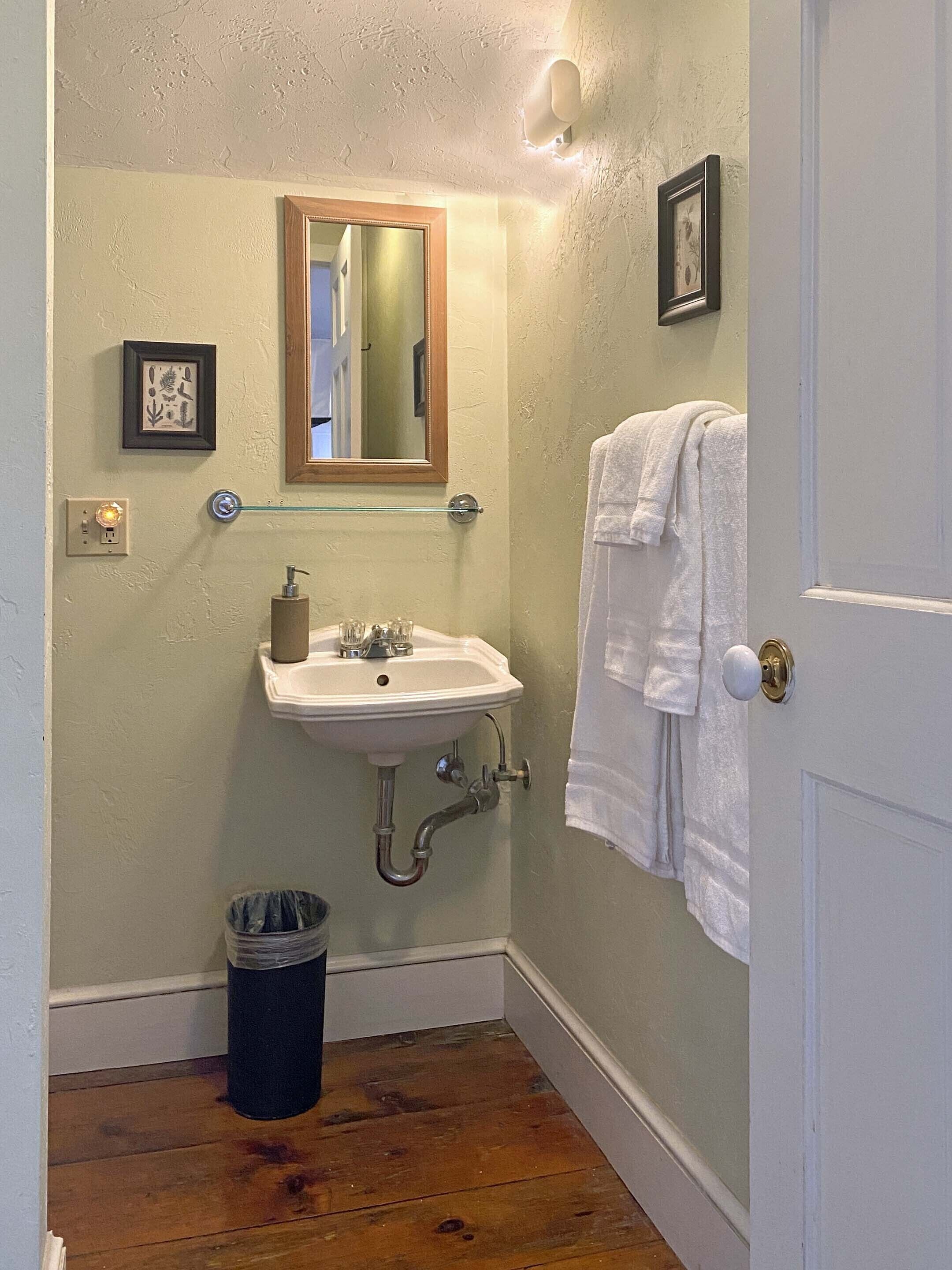 A bathroom with a sink, mirror, and towel rack.