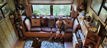 Una habitación acogedora con sofá, una mesita y una ventana con plantas.