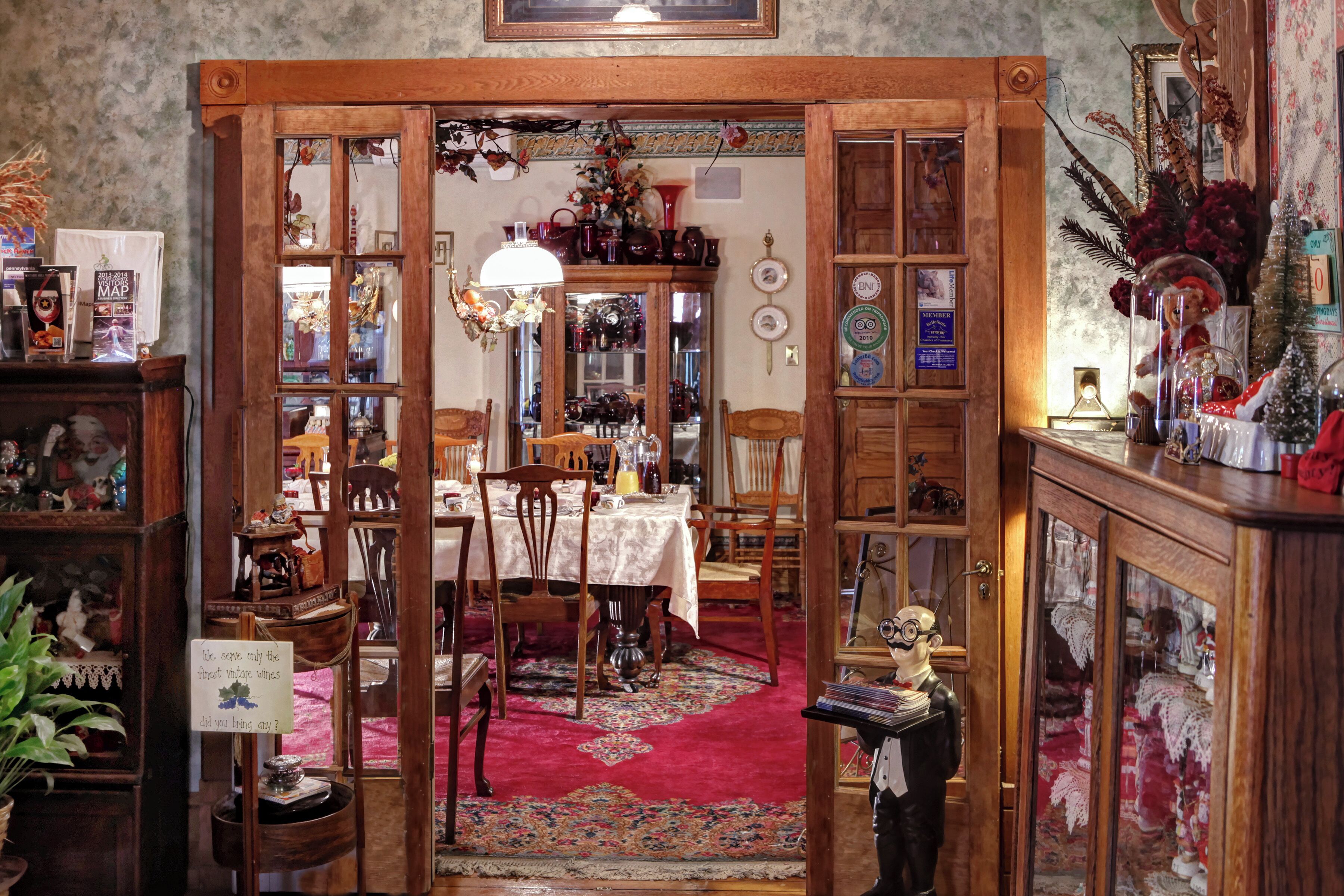 A traditional dining room with a wooden table, chairs, and a red carpet.