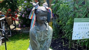 Una estatua de jardín que representa a una niña y un niño.