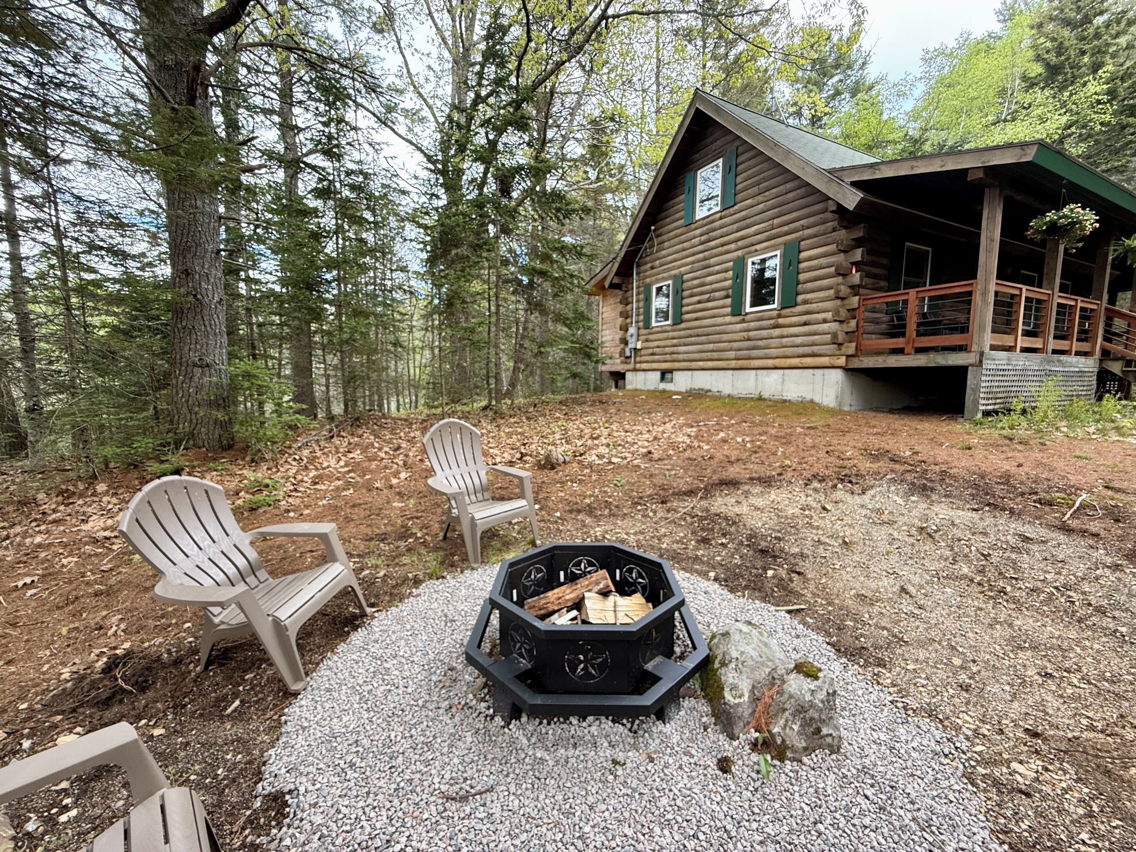 Eine Hütte mit einer Terrasse, umgeben von Bäumen.