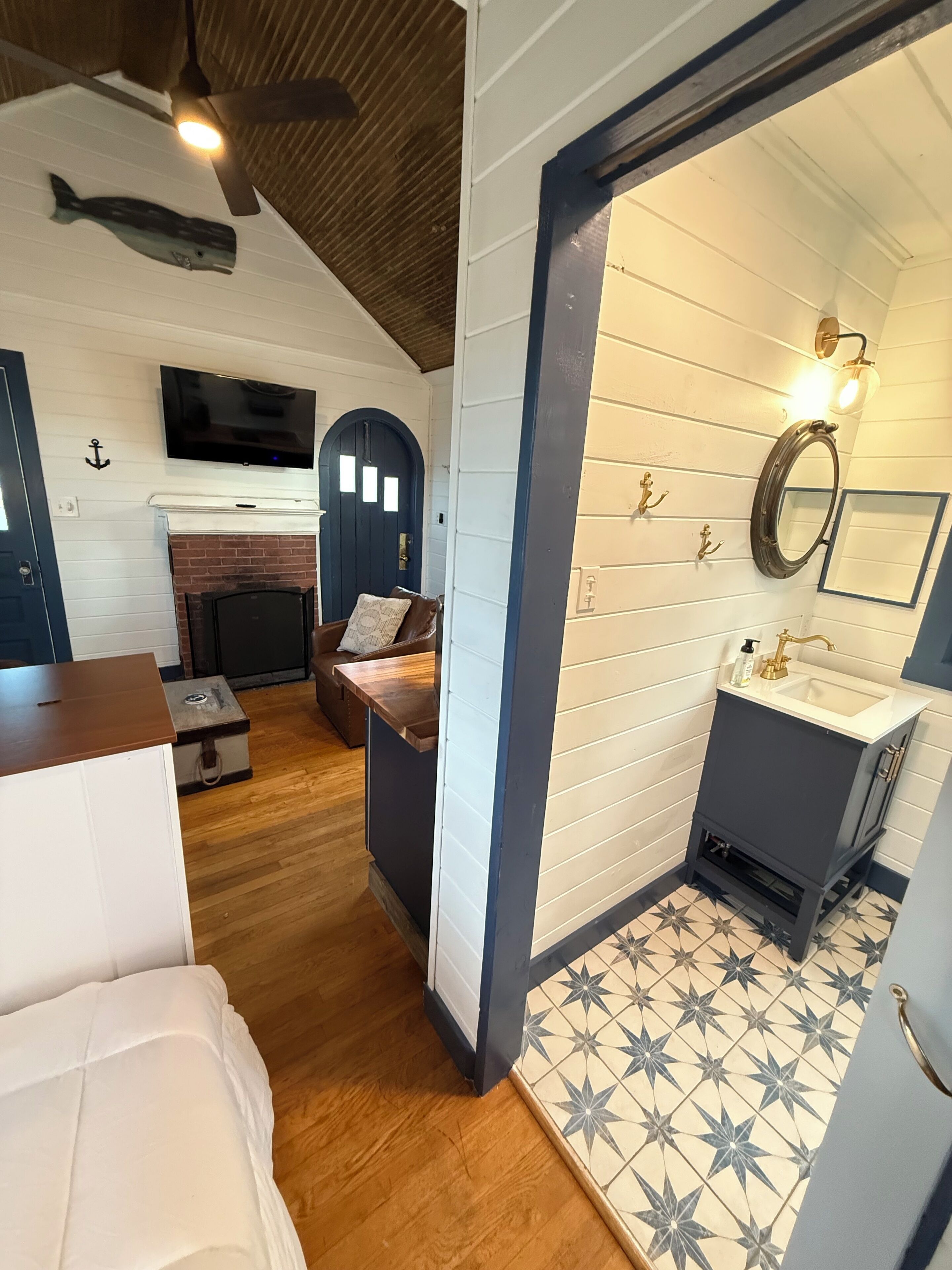 Um quarto aconchegante com lareira, televisão, cama e banheiro com piso estampado em formato de estrela.