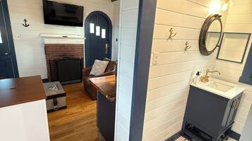 Um quarto aconchegante com lareira, televisão, cama e banheiro com piso estampado em formato de estrela.