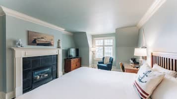 Une chambre avec une cheminée, une télévision, un bureau avec une lampe et une chaise.