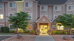 A multi-story hotel with a stone facade, large windows, and a well-lit entrance.