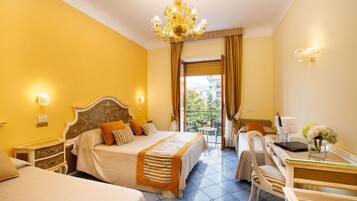 Vierpersoonskamer, balkon | Een minibar, een kluis op de kamer, een bureau, geluiddichte muren