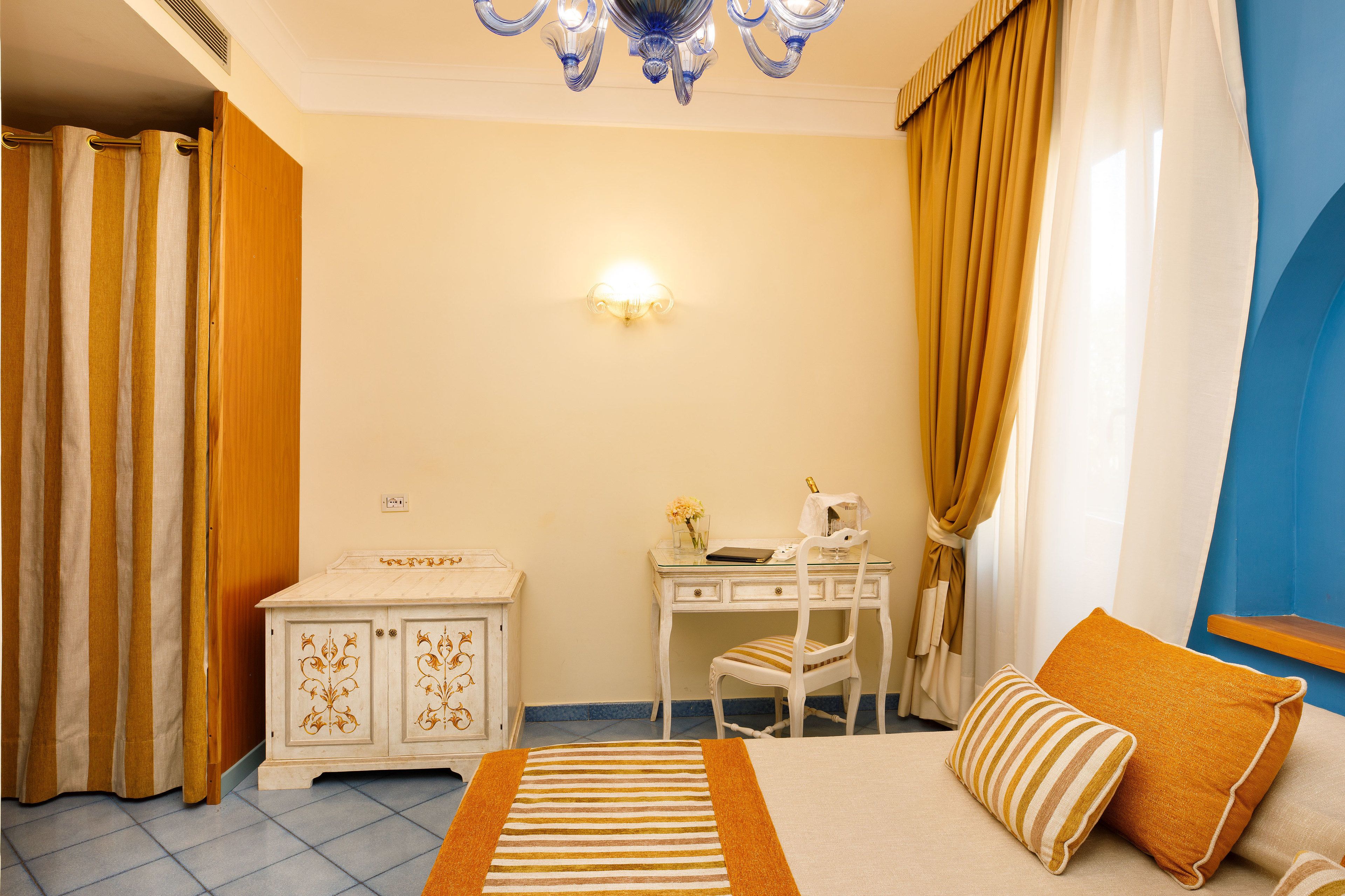 A hotel room with a bed, a desk, a chair, and a wardrobe.