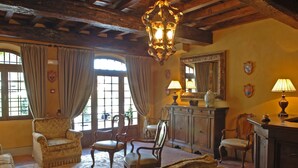 A traditional room with wooden beams, a chandelier, and classic furniture including armchairs and a sofa. - Hotel Residenza Torre di San Martino (Gazzola)