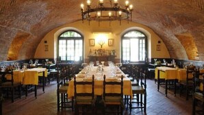 A large dining hall with high arched ceilings and a central chandelier. Tables are set with chairs, and there are windows along the walls. - Hotel Residenza Torre di San Martino (Gazzola)