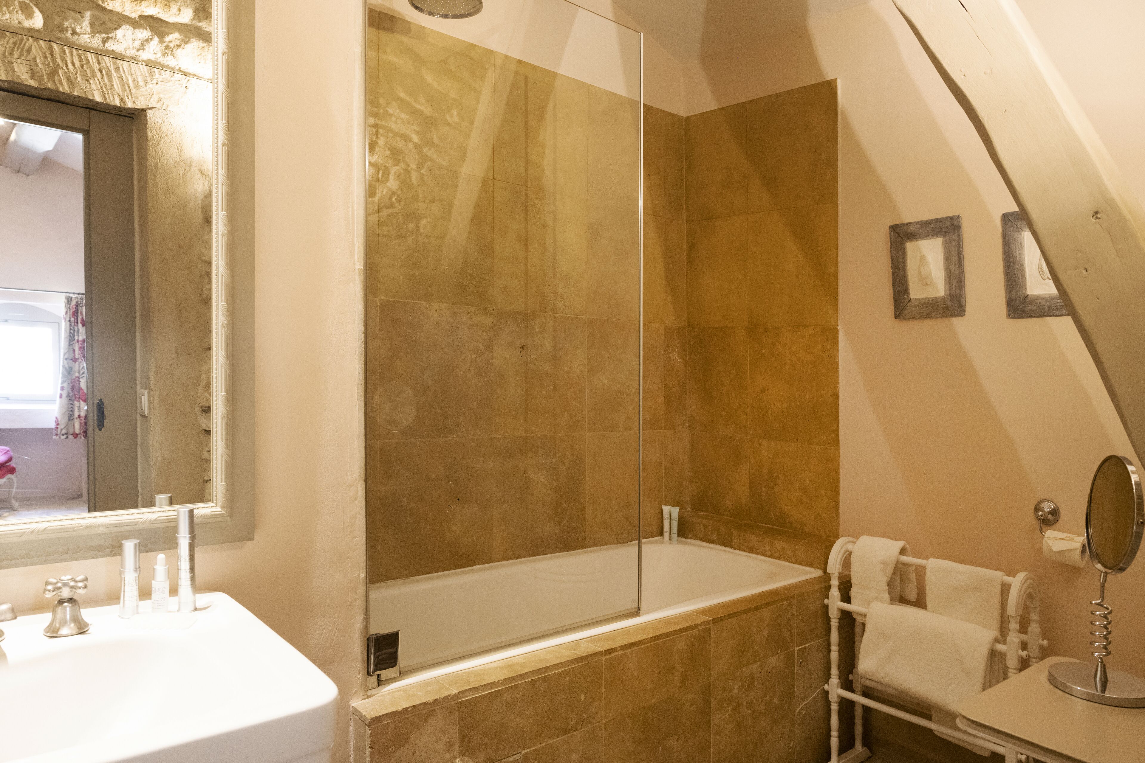 A bathroom with a bathtub, a shower, a sink, and a mirror.