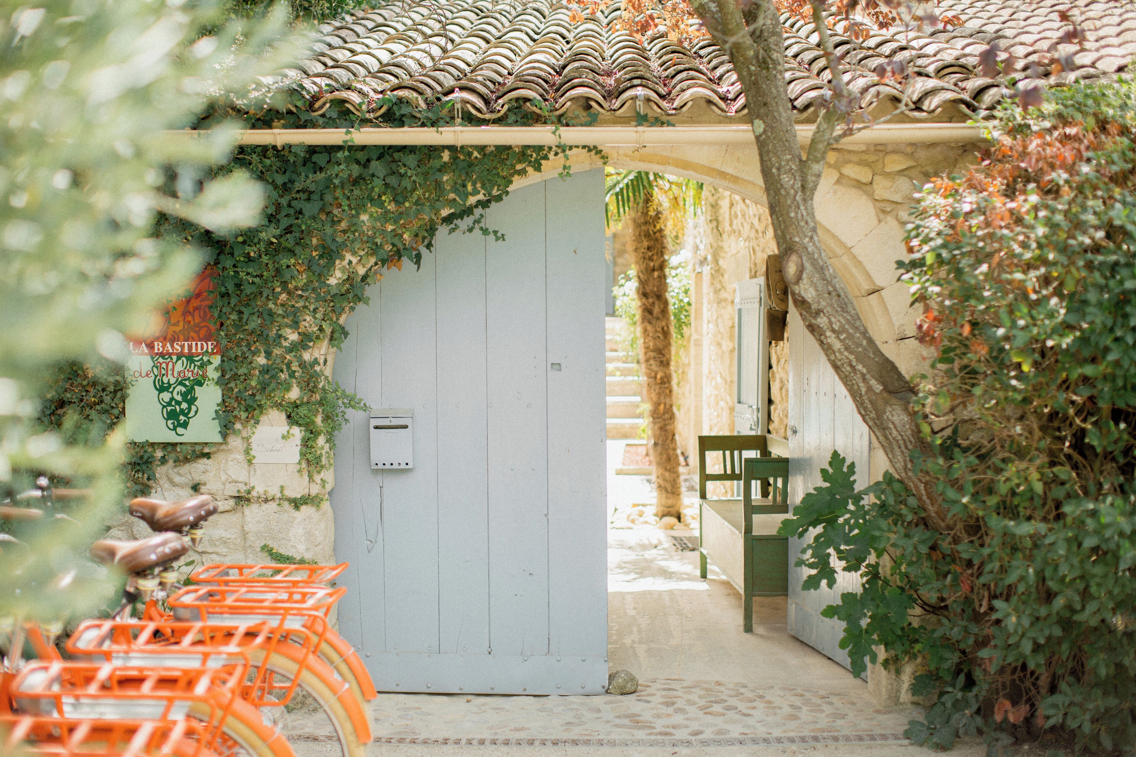 Una porta rústica amb teulada de rajola, una porta de fusta i una panxa de peu a la dreta.