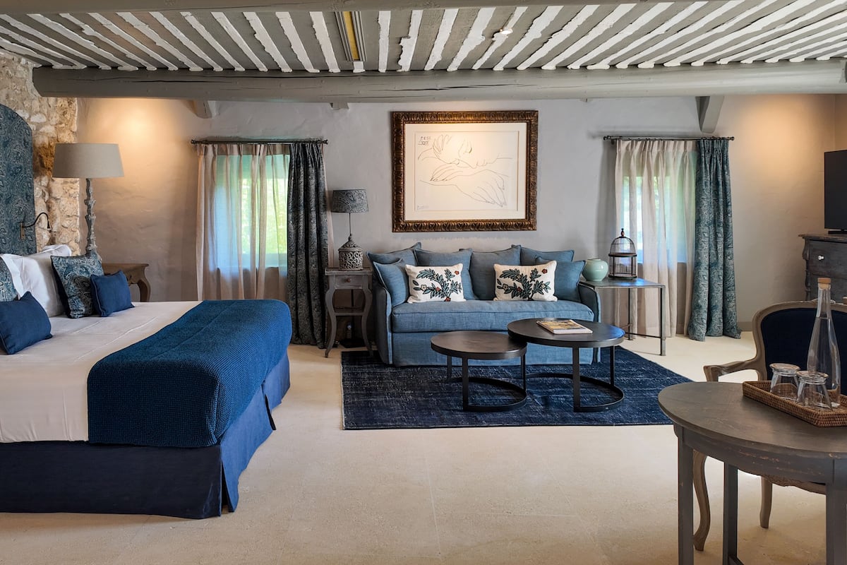 Une chambre à coucher avec un lit, un canapé, une table basse et un téléviseur.