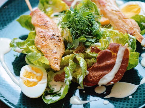 A salad with various ingredients including lettuce, a boiled egg, and a piece of meat. - Mövenpick Hotel Stuttgart Airport (Leinfelden-Echterdingen)