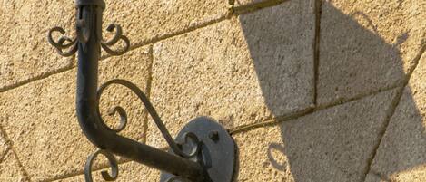A wall-mounted outdoor light fixture with a decorative design.