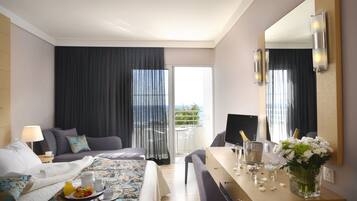 Une chambre d’hôtel avec un lit, un bureau avec un ordinateur, une chaise, une petite table avec un plateau de nourriture, un vase de fleurs et un grand miroir.