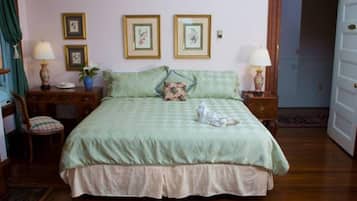 A bedroom with a bed, two bedside tables with lamps, a chair, and a door.