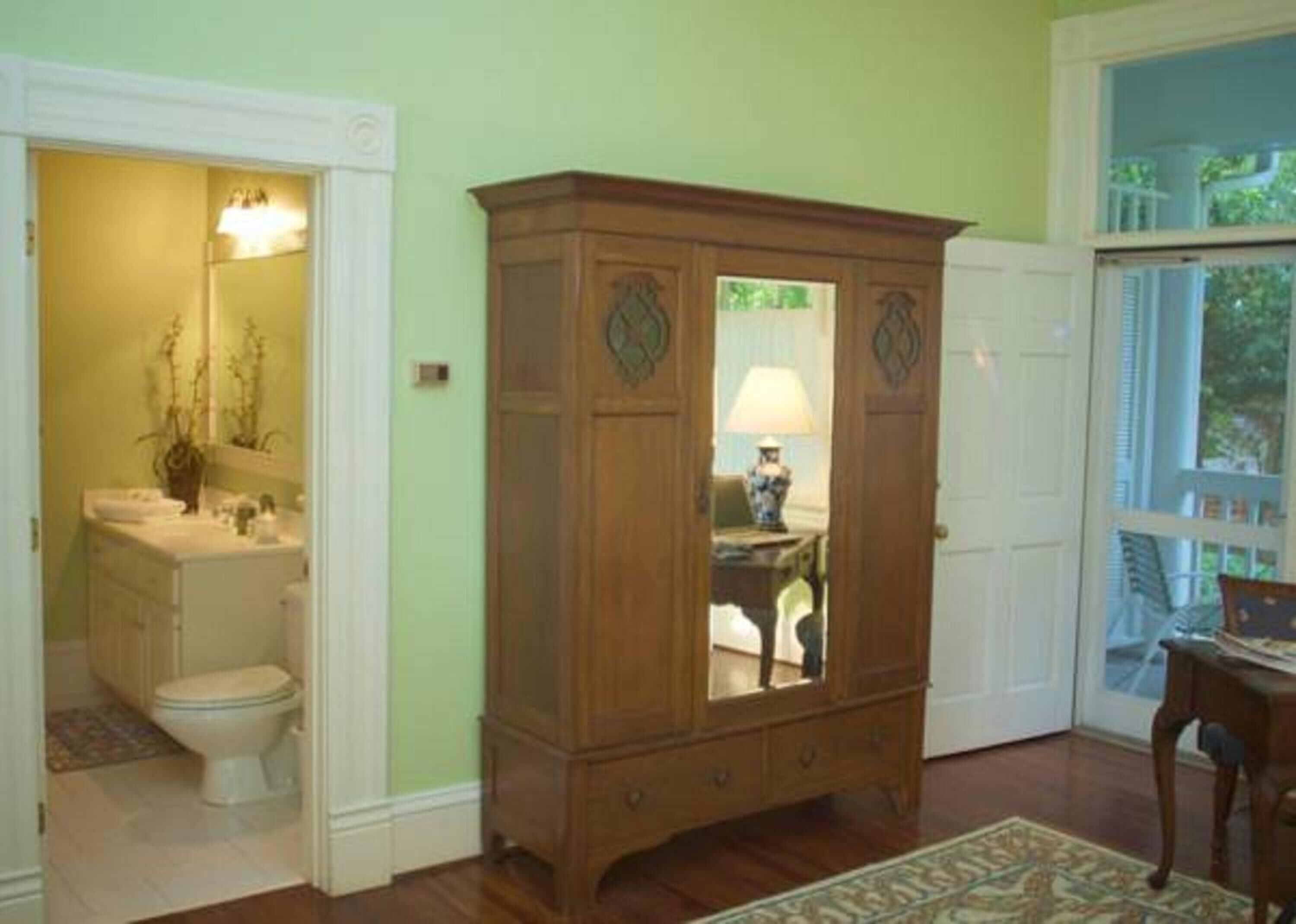 Une pièce avec un meuble en bois, des toilettes et une fenêtre.