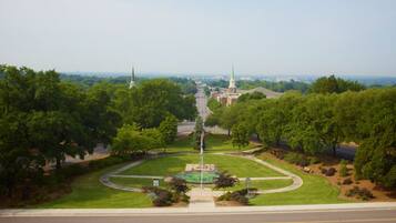 A park with a central monument, surrounded by trees and a clear sky.