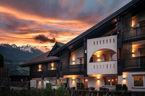 A modern hotel with a two-story structure, balconies, and a view of snow-capped mountains. - Vitaurina Royal Hotel (Campo Tures)