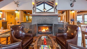 A cozy living room with leather chairs, a fireplace, and a large mirror above it.