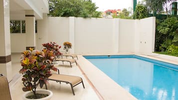 Una piscina al aire libre, tumbonas