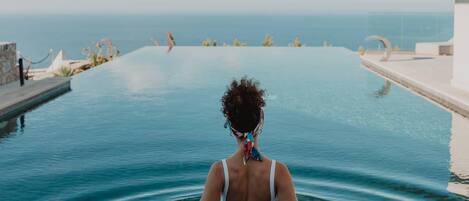 A person in a swimming pool with a view of the ocean.