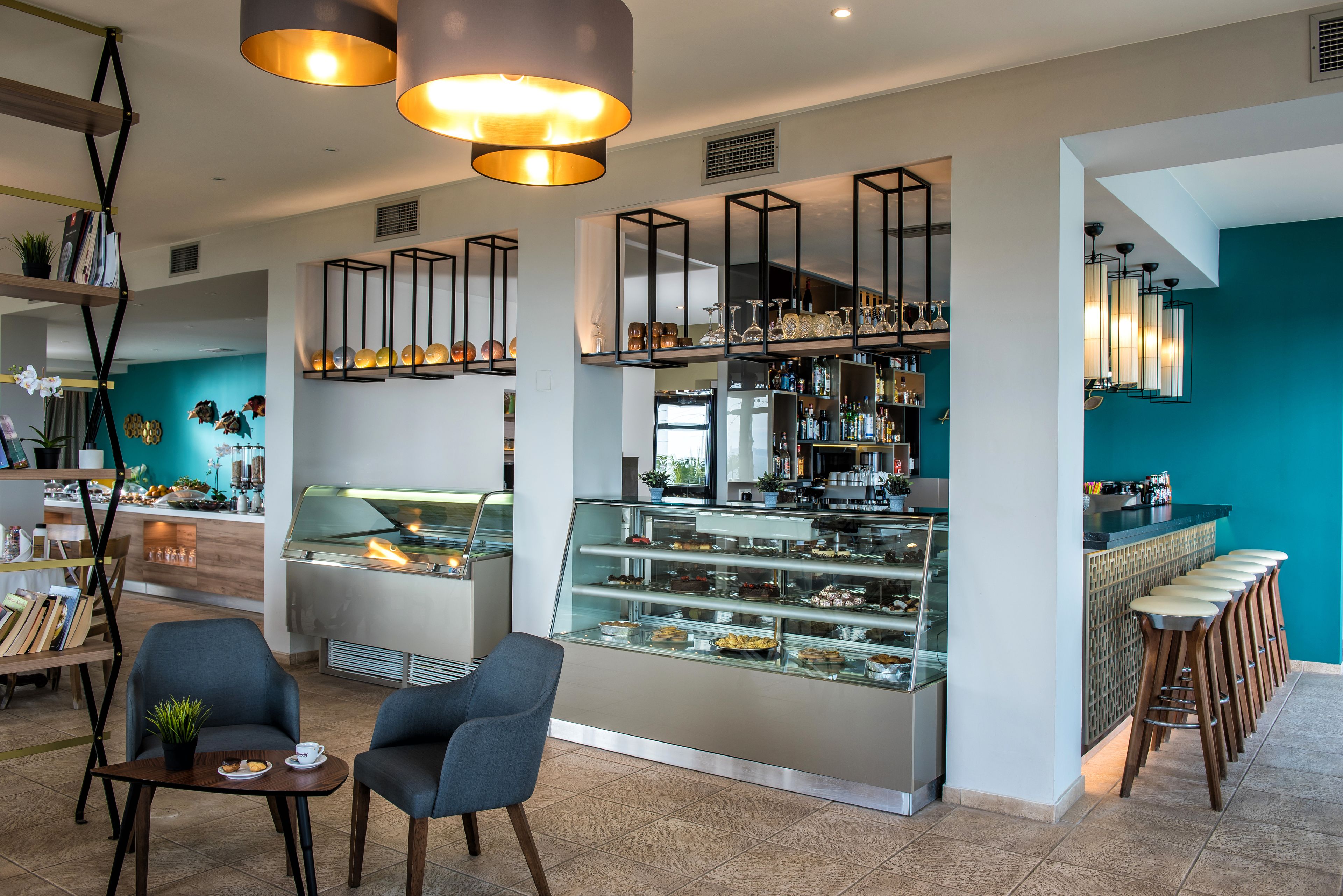 A modern cafe with a glass display case, bar area, and seating.
