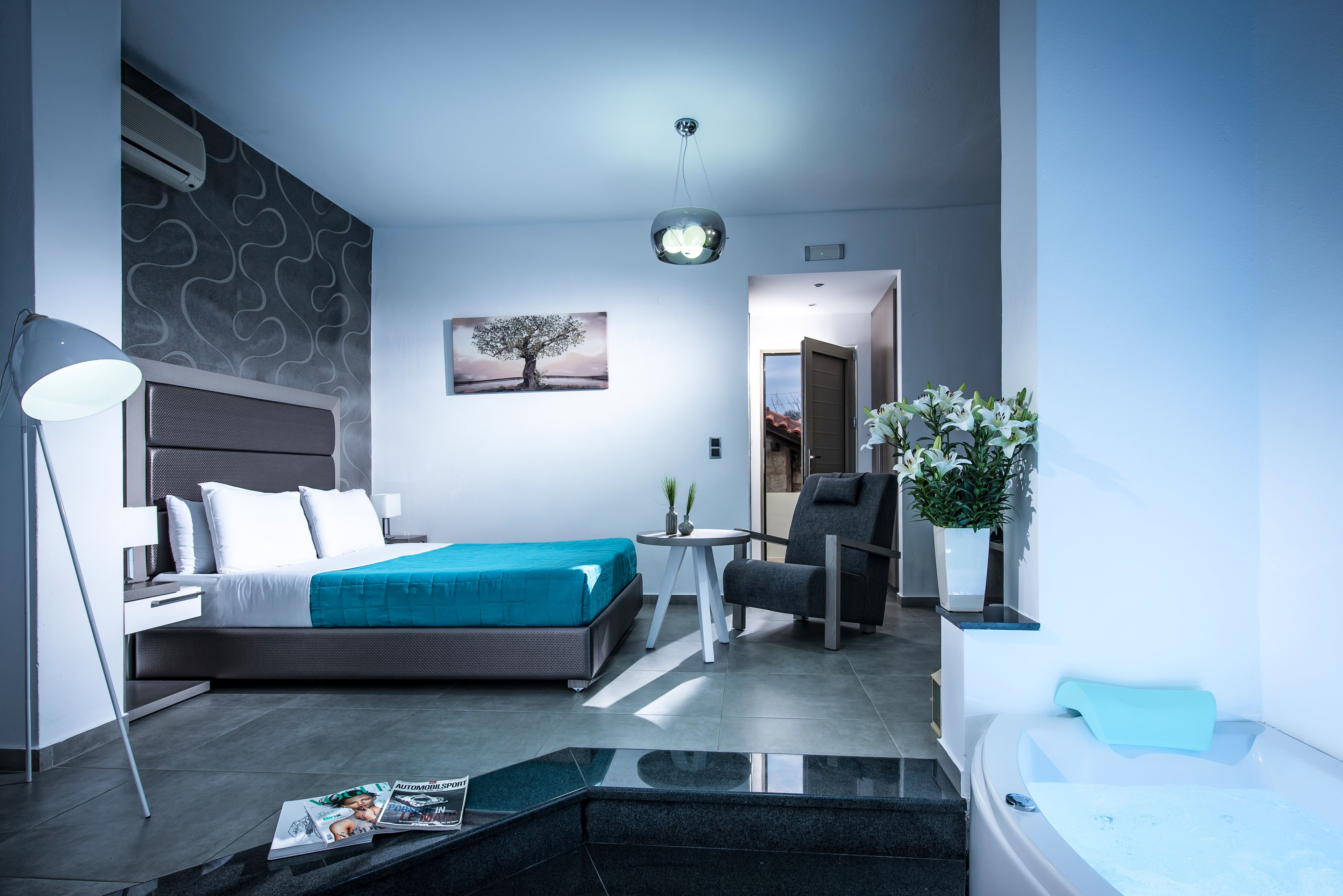 Ein modernes Schlafzimmer mit Bett, Nachttisch, Lampe und Blick auf den Flur.