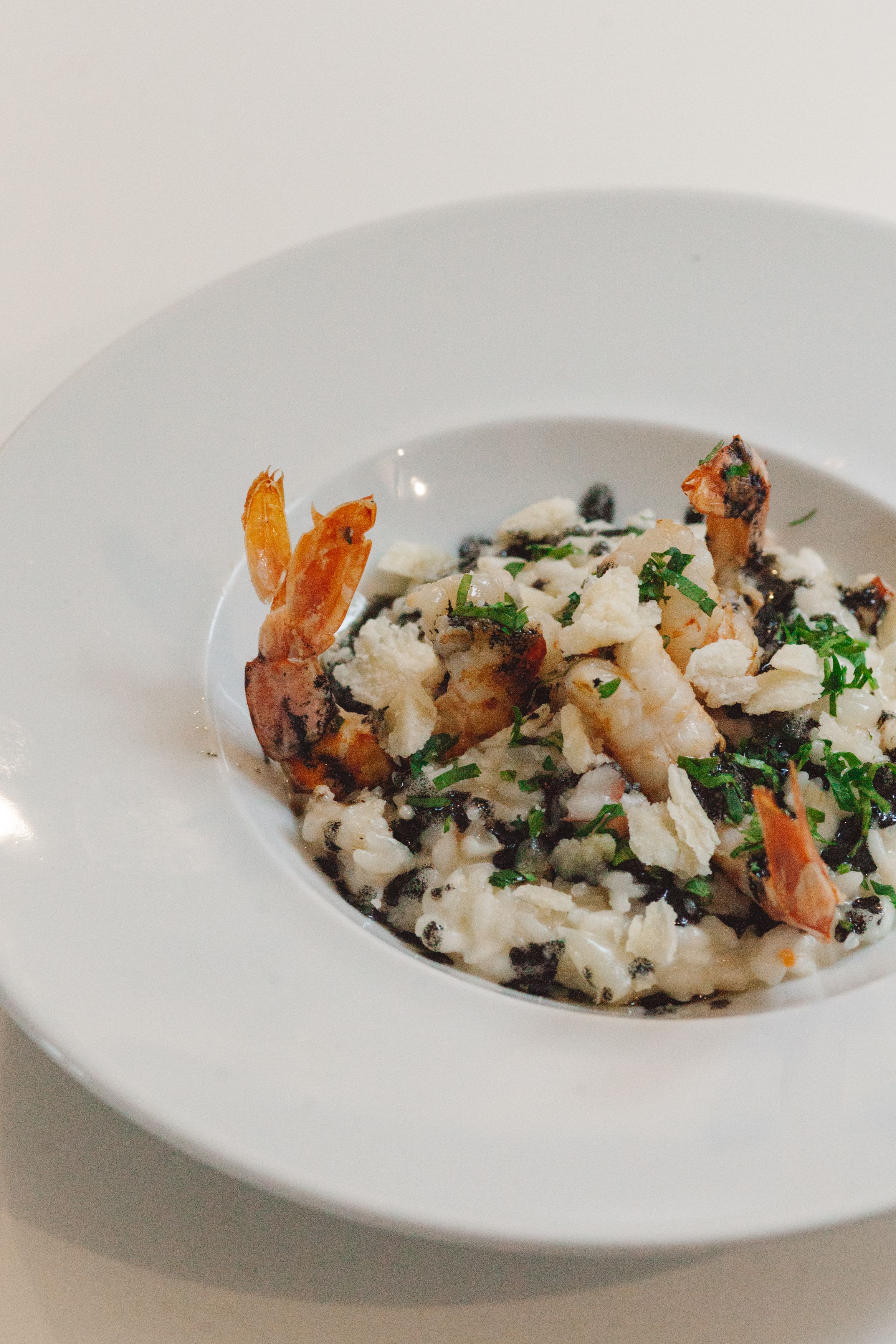 Une assiette de risotto aux fruits de mer, garnie d’herbes aromatiques.
