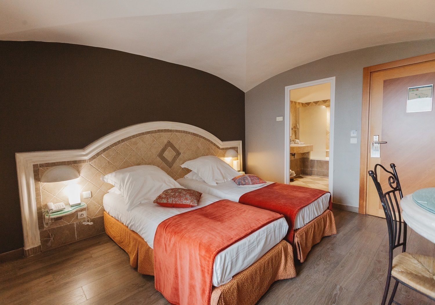 Un lit double avec deux oreillers, une table de chevet avec une lampe et une chaise.