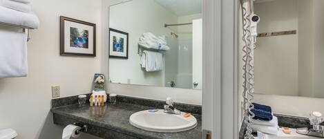 A bathroom with a sink, mirror, towel rack, and toilet.