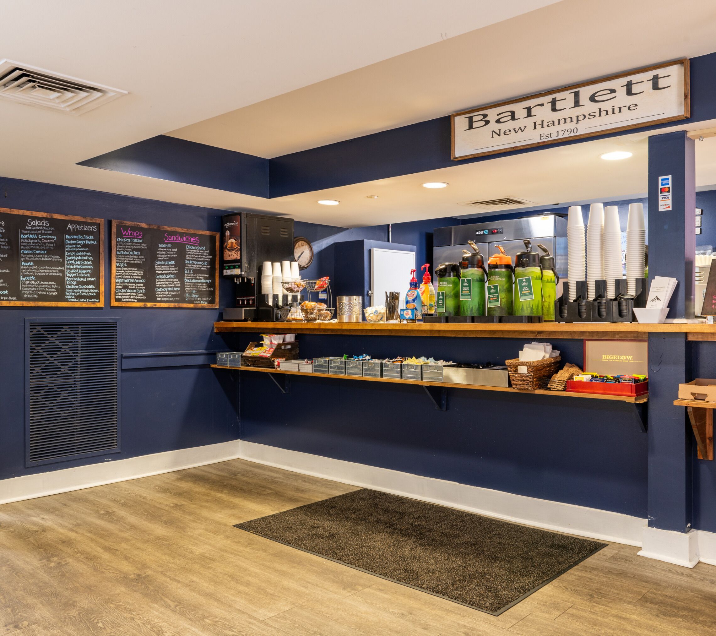 A Bartlett New Hampshire restaurant interior with a dark blue theme, a menu board, and a coffee machine.