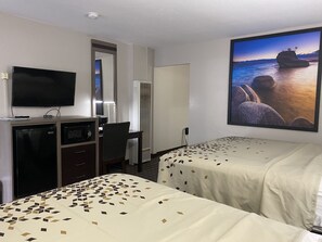 Ett hotellrum med två sängar, ett skrivbord, en tv och ett stort fönster med vacker utsikt.