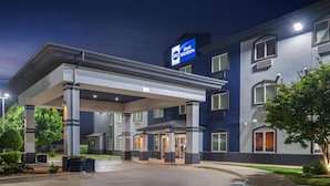 Un hotel Best Western con vestíbulo cubierto, múltiples ventanas y un cartel.