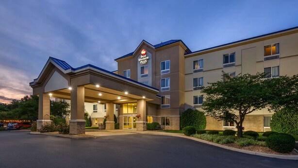 Ein Best Western Plus Hotel mit überdachter Zufahrt, mehreren Etagen und einem begrünten Außenbereich mit Bäumen.