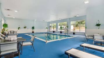 Una piscina techada, sillones reclinables de piscina