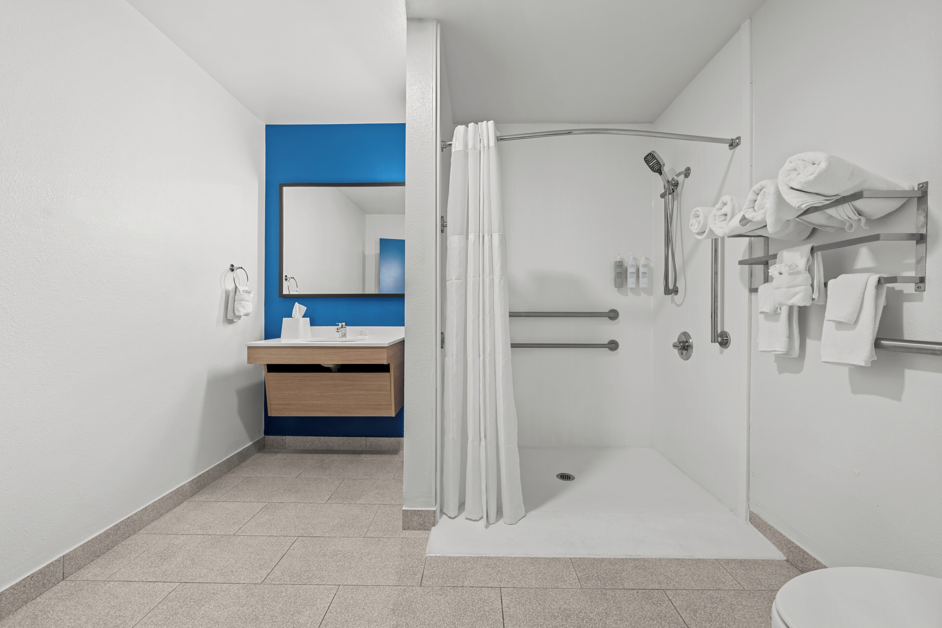 A modern bathroom with a shower, toilet, and sink.