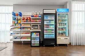 A vending area with snack and drink options, a microwave, and a refrigerator. - Spark by Hilton Pelham Birmingham I 65 (Pelham)