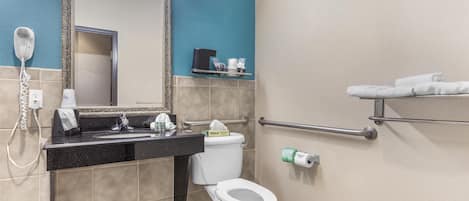 A bathroom with a sink, toilet, and a mirror.