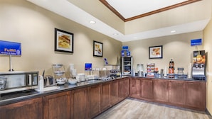 A breakfast bar with a microwave, coffee makers, and a variety of food items. - Best Western Mineola Inn (Mineola)
