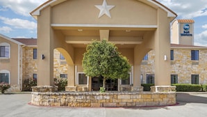 A hotel with a prominent star logo, stone facade, and a landscaped entrance area. - Best Western Mineola Inn (Mineola)