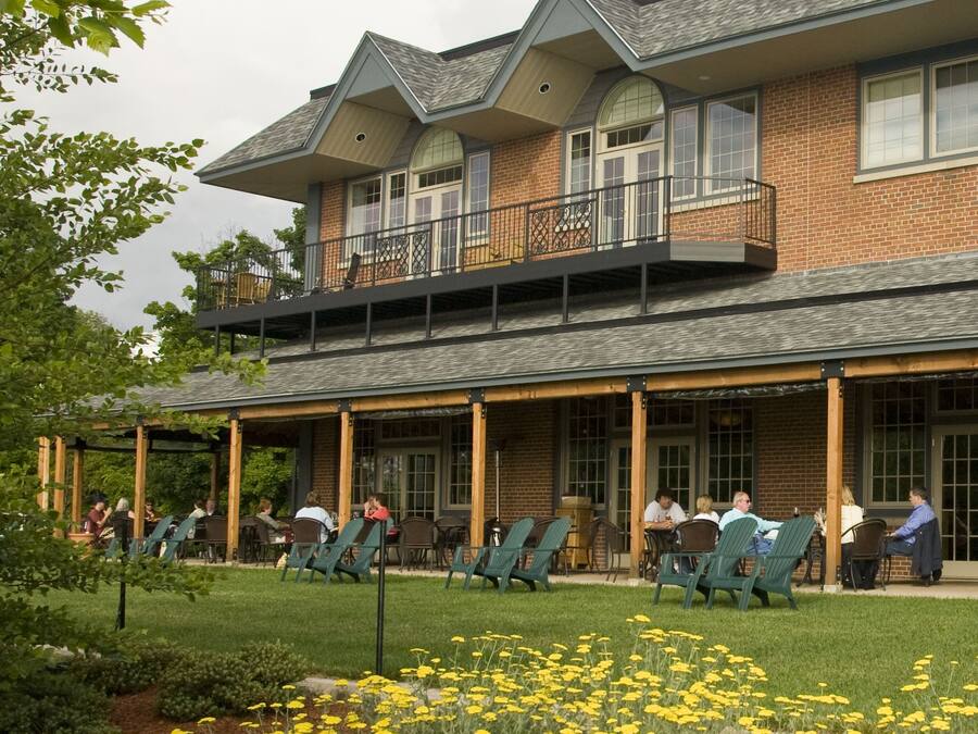 A two-story building with a covered patio area and outdoor seating.