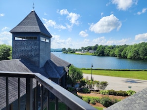 A building with a tower and a view of a lake and greenery. - Lake Opechee Inn and Spa (Laconia)