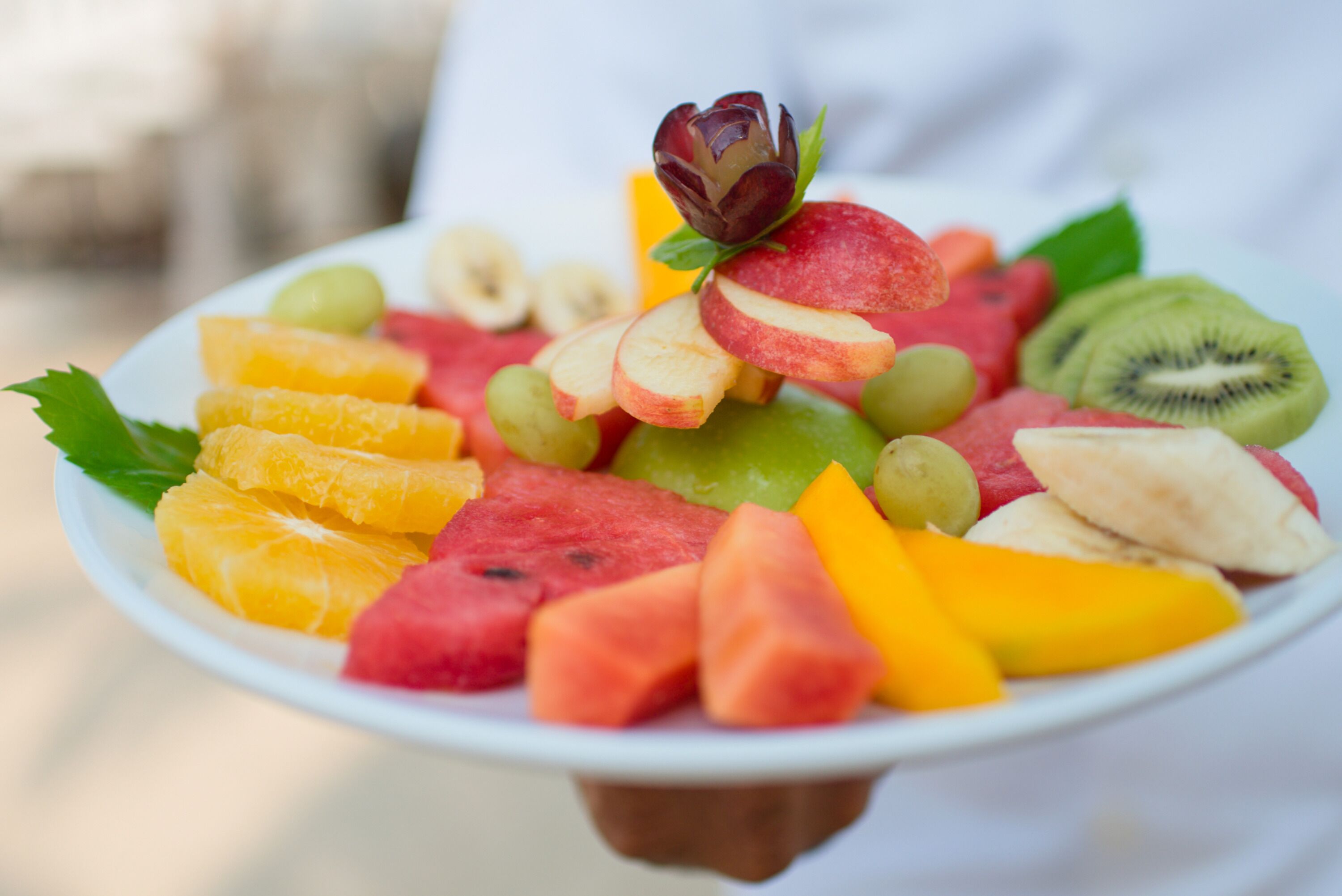 Un plato con una variedad de frutas, incluyendo sandía, kiwi y rodajas de manzana.