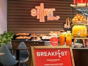Un área de desayuno con un cartel que dice 'BREAKFAST' y un cartel que indica 'FRUITS STAGE'.
