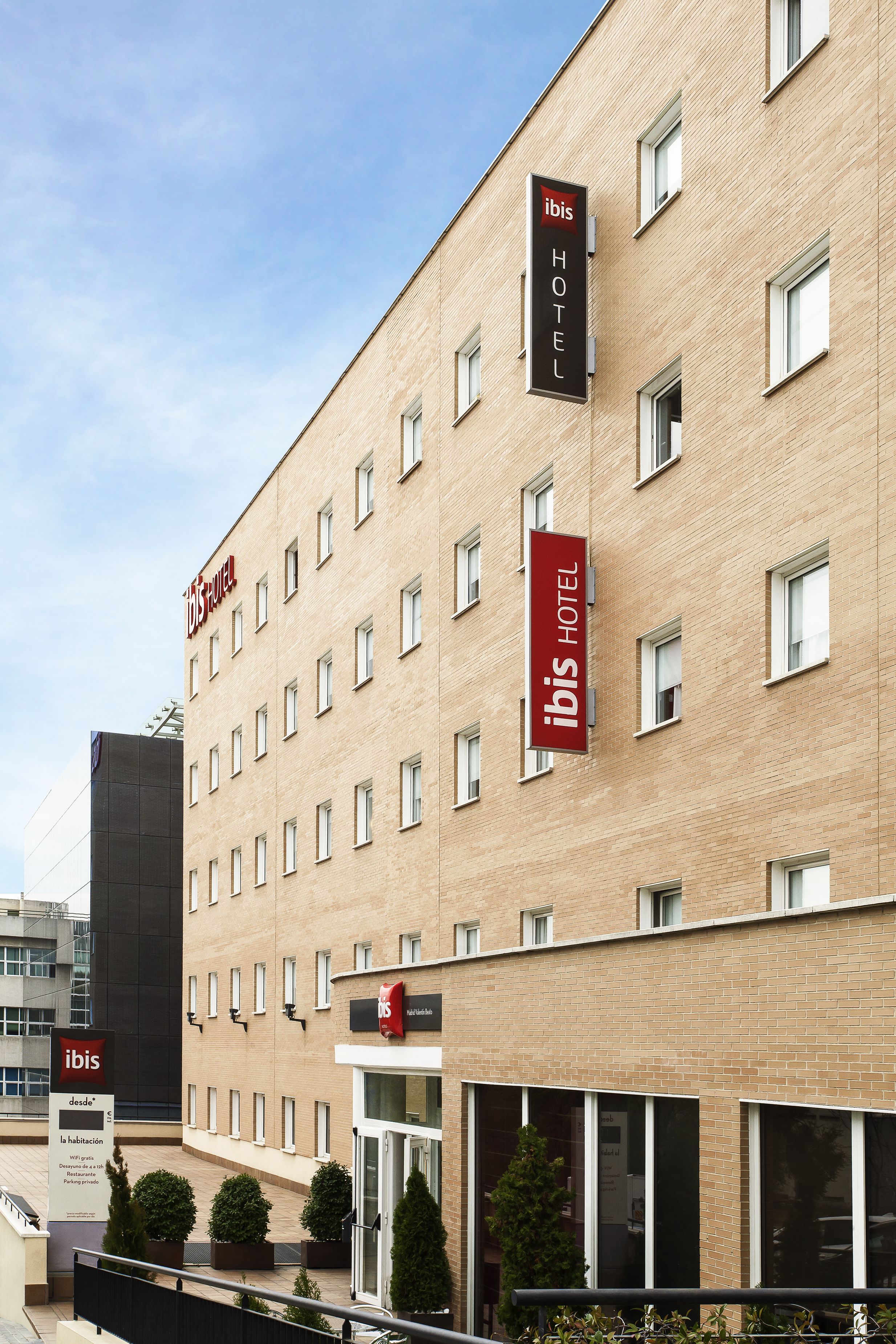 A hotel with multiple floors, a prominent "ibis Hotel" sign, and a modern facade.