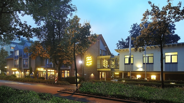 Ett hotell med flera byggnader, inklusive en framträdande byggnad med en neonreklamskylt.
