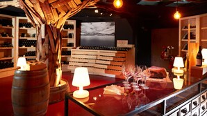 A wine cellar with wooden barrels, wine racks, and a display of wine bottles.
