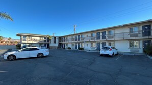 Un motel a due piani con un parcheggio.