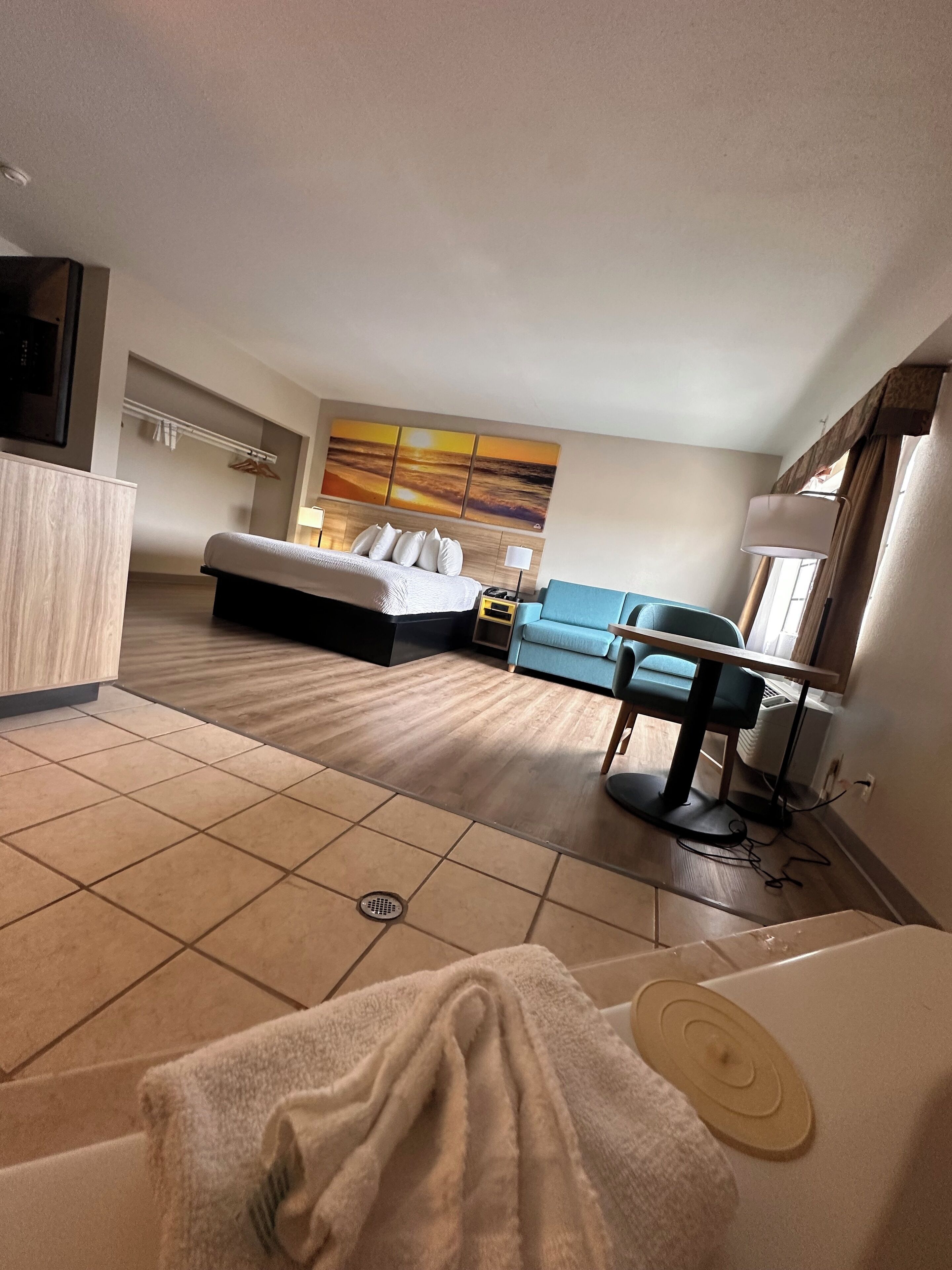 Une chambre d’hôtel avec un lit, un canapé, un bureau et une salle de bain.